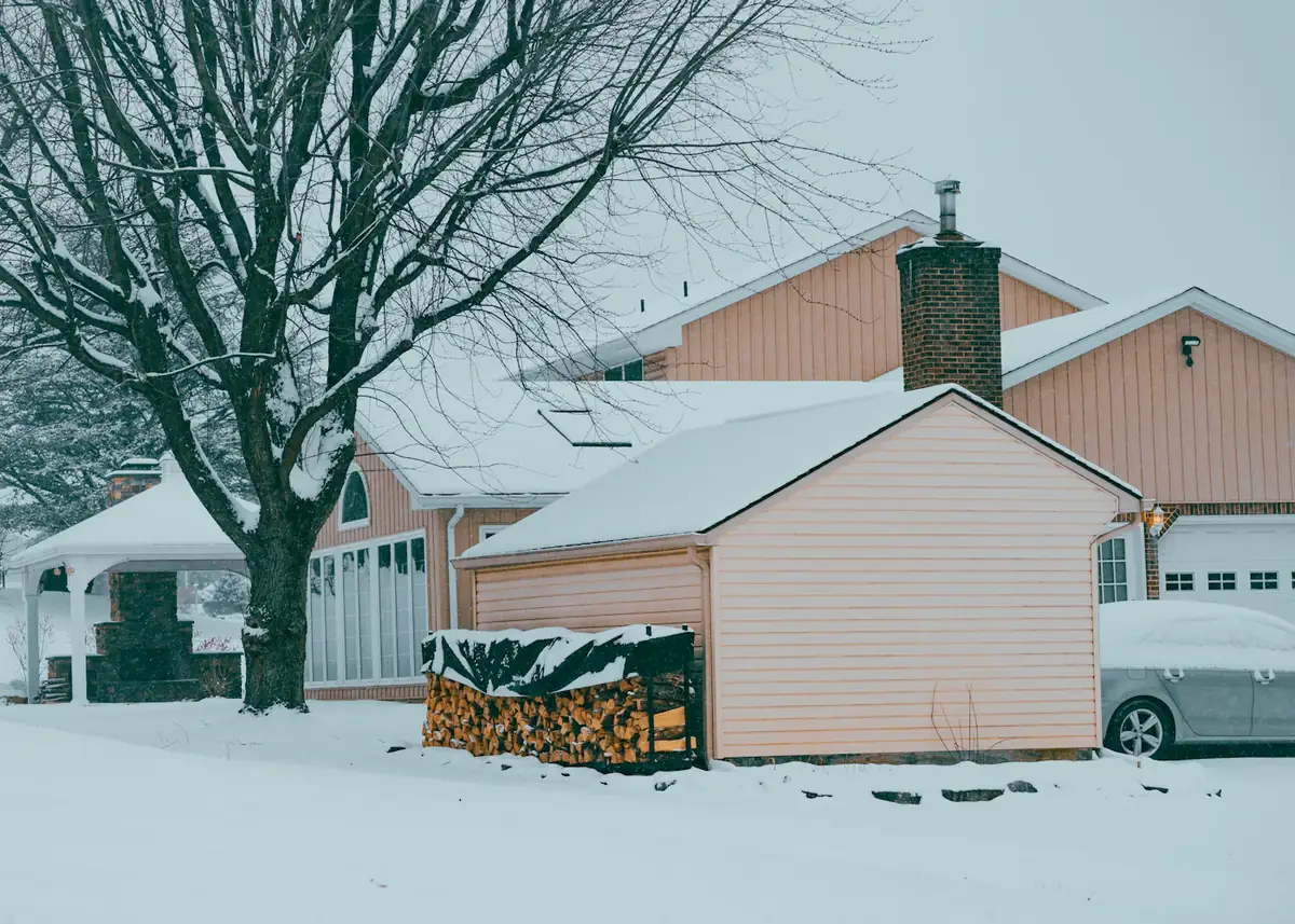 A house and its garage covered in fresh snow